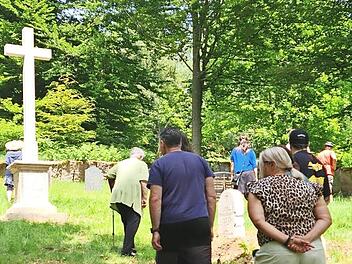 Besucher auf dem Friedhof Altglash&uuml;tten. Im Hintergrund steht das neue Sandsteinkreuz.