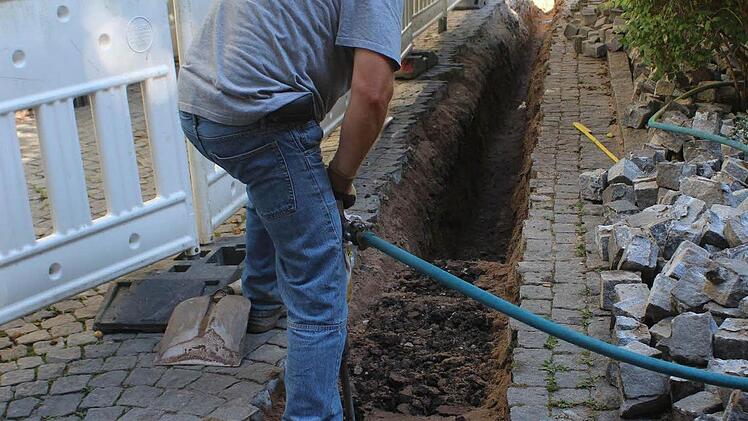 Schweißtreibend ist das Aufgraben der alten Asphaltdecke unter dem Pflaster Am Graben. Foto: Andreas Dorsch