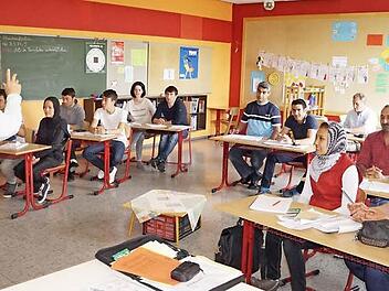 Deutschunterricht in einer Klasse mit Flüchtlingen. Das Bild zeigt den Bischofsheimer Lothar Lindner.  Foto: Marion Eckert