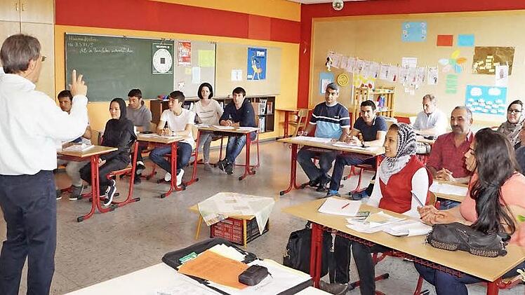 Deutschunterricht in einer Klasse mit Flüchtlingen. Das Bild zeigt den Bischofsheimer Lothar Lindner.  Foto: Marion Eckert