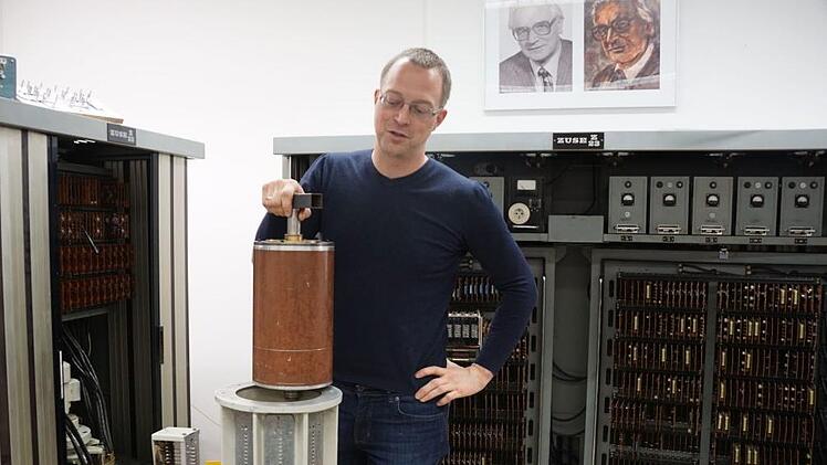 Marcel Ritter, stellvertretender Leiter des RRZE, zeigt die Magnettrommel einer Rechenanlage von 1962. Die Zuse Z23, bestehend aus den Schr&auml;nken links, geradeaus, der Magnettrommel und einem Bedienpult (nicht im Bild), ist funktionsf&auml;hig. Foto: Pascale Ferry