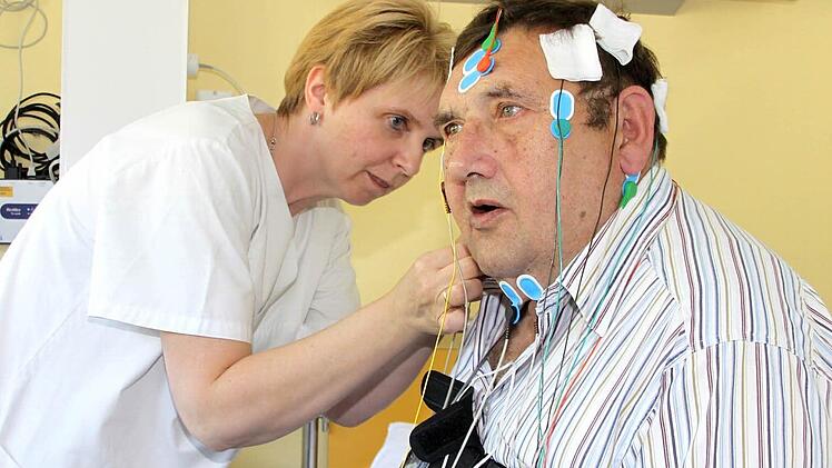Mit geübten Handgriffen verkabelt Carmen Thierauf, medizinische Fachangestellte im Schlaflabor, Reinhard Beetz für die Analyse seines Schlafes. Mit Hilfe der Elektroden werden verschiedene Körperfunktionen erfasst. Aus den aufgezeichneten Daten wird ein so genanntes Polysomnogramm erstellt, das detaillierte Informationen über die Schlafqualität liefert. Fotos: Dagmar Besand.