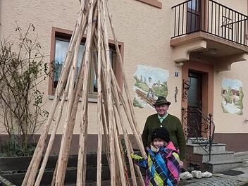 Die drei bis vier Meter lange Tannenstämmchen müssen noch ein Jahr lang trocknen, bis daraus ein Floßhaken werden kann. Mit im Bild Ehrenvorsitzenden Ottmar Zwingmann mit seiner achtjährigen Enkelin Annamaria. Foto: Gerd Fleischmann