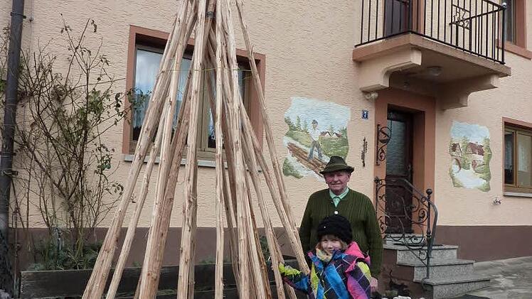 Die drei bis vier Meter lange Tannenstämmchen müssen noch ein Jahr lang trocknen, bis daraus ein Floßhaken werden kann. Mit im Bild Ehrenvorsitzenden Ottmar Zwingmann mit seiner achtjährigen Enkelin Annamaria. Foto: Gerd Fleischmann