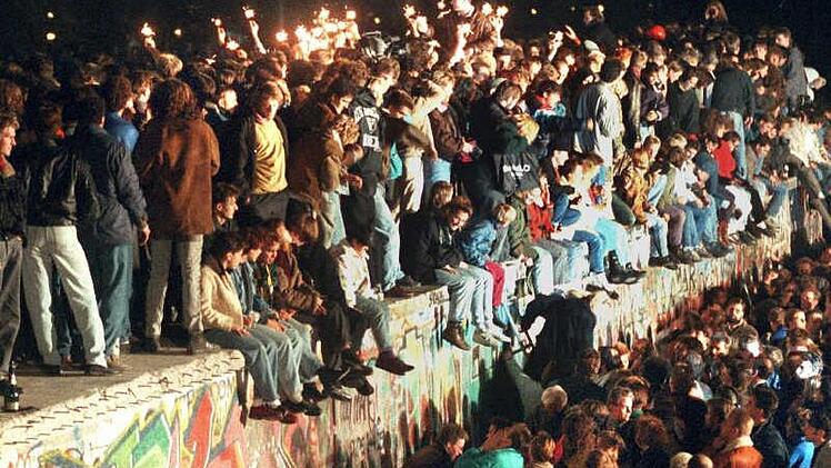 1989: Jubelnde Menschen auf der Berliner Mauer. Archiv / dpa
