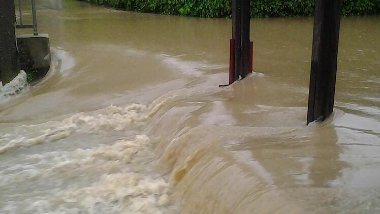 Über das TSV-Geländer in der Fröschau in Neunkirchen ergießt sich eine Sturzflut. Foto: Frank Hofmann
