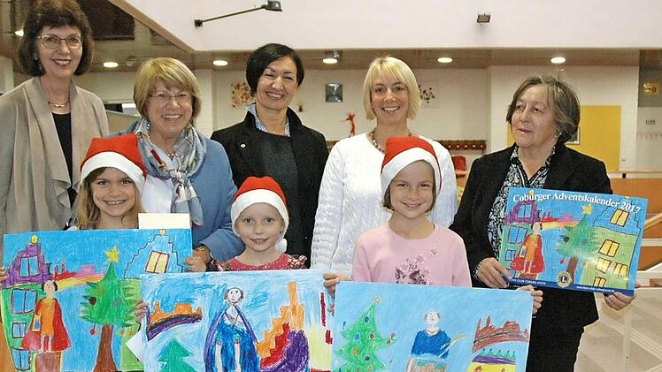 Bunt und fröhlich erscheint der Coburger Adventskalender 2017 des Lions Club Coburg Veste. Besonders freuen sich die drei jungen Künstlerinnen über die Prämierung ihrer Bilder. Vorn von links: Julia Tilche, Heidi Lengdobler, Stephanie Günther. Auch die Mitglieder des Lions Club Coburg Veste und die Rektorin der Heimatringschule freuen sich mit. Hinten von links: Gabriele Gruschwitz, Rektorin Marie-Luise Albrecht-Müller, Ingrid Nassios, Sonja Erdel, Gudrun Zaddach  Foto: Edwin Meißinger