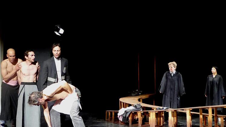 Der große Showdown in der Gerichtsszene von Shakespeares "Kaufmann von Venedig": Shylock (Stefan Plepp) hat schon das Messer in der Hand, um Antonio, der dies mit entblößter Brust erwartet (Oliver Rickenbacher), das verpfändete Pfund Fleisch herauszuschneiden. Flankiert wird er von seinen Freunden   Bassanio (links: Daniel Schröder) und Gratiano (Benjamin Plath). Im Hintergrund bereiten Portia (links: Vera Kreyer) als Rechtsgelehrter und ihre Freundin Nerissa (Kim Pfeiffer) als ihr Diener ihr...