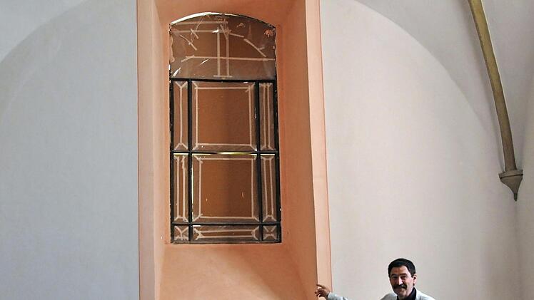 Dekan Jürgen Blechschmidt zeigt das Altarfenster, das in den 1930er Jahren zugemauert worden ist und nun wieder geöffnet wurde.