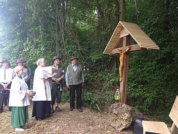 Am Weg zwischen Eltingshausen und Schwarzer Pfütze errichteten die Jagdpächter Georg Zänglein Senior und Junior ein Feldkreuz aus Dankbarkeit nach Schicksalsschlägen, von denen sie sich wieder erholten. Auf unserem Foto segnet Pfarrer Balthasar Amberg das Kreuz. Rechts von ihm Vater und Sohn Zänglein. Fotos: Stefan Geiger