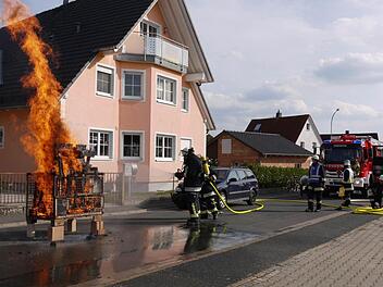 Die Atemschutzträger demonstrierten, wie man ein Feuer mit einem kompakten Schlauch aus dem neuen Fahrzeug löscht. Foto: Pauline Lindner