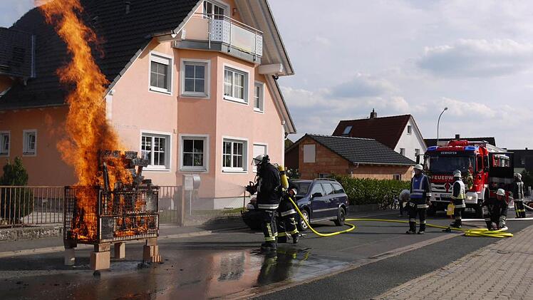 Die Atemschutzträger demonstrierten, wie man ein Feuer mit einem kompakten Schlauch aus dem neuen Fahrzeug löscht. Foto: Pauline Lindner