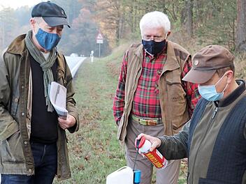 Michael Schießwohl (rechts) demonstriert an der Kreisstraße KC 25 zwischen Gundelsdorf und Friesen, wie der im Multiwildschutzwarner enthaltene Schwamm mit "Duftstoff" nachgefüllt wird. Ebenso Experten bei Wildunfallschutzmaßnahmen sind der Leiter des Projekts "Wild und Straße", Klaus Riedel (links), und Jagdpächter Reinhard Rüger, der an der Kreisstraße KC 17 zwischen Marienroth und Teuschnitz mit den gleichen Maßnahmen erfolgreich arbeitet. Foto: Rainer Glissnik