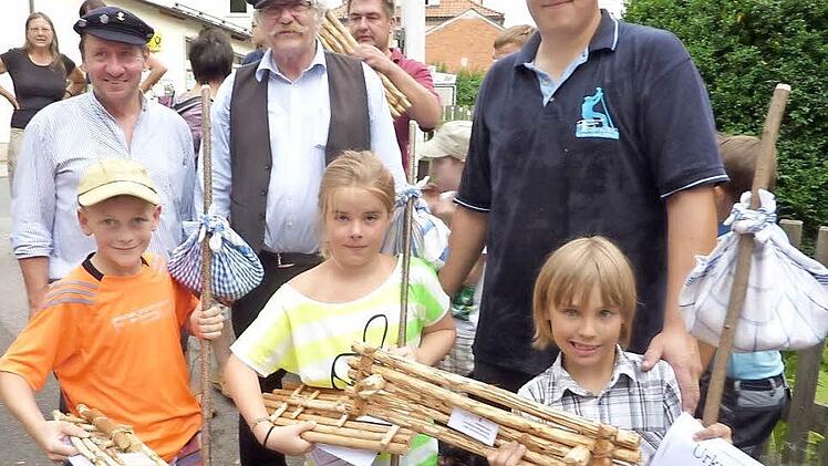 Stolz präsentierten die drei Hauptsieger Maximilian Dietl, Moses Röder und Anna Schmied ihre 40 Zentimeter großen Floßmodelle. Mit im Bild (von links): Bürgermeister Norbert Gräbner, Vorsitzender Friedrich Fricke und Floßmeister Michael Thiemann. Foto: Gerd Fleischmann