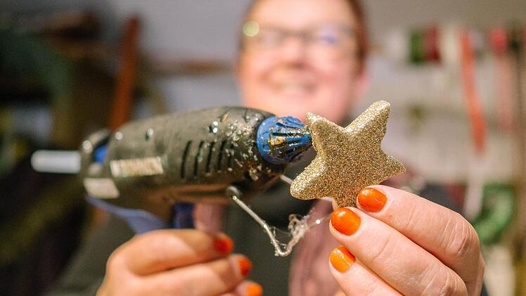 Neben goldenen Ziersternen nutzt Jutta Markert auch natürliche Beeren, Koniferen der Muschelzypresse oder aus Filz ausgeschnittene Bänder, um Adventskränze in ihrem Zeiler Blumengeschäft zu dekorieren. Foto: Marian Hamacher