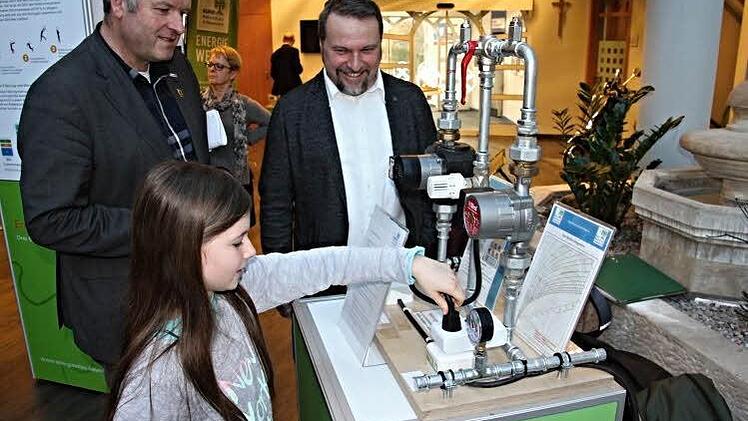 Technisch an Wärmepumpen interessiert: Die achtjährige Mia, über deren Begeisterung sich (hinten von links) Bürgermeister Jürgen Hennemann und Rektor Philipp Arnold von der Mittelschule Ebern freuen. Foto: Helmut Will