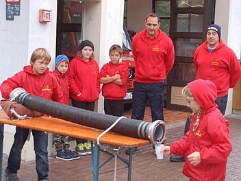Aufregung liegt in der Luft: Die Mädchen und Jungen üben für den zweiten Kinderfeuerwehr-Leistungsmarsch in Oberfüllbach die Wasserbeförderung durch den Saugschlauch. Es schauen Michael Müller (links) und Michael Baudler zu.  Fotos: Gabi Arnold