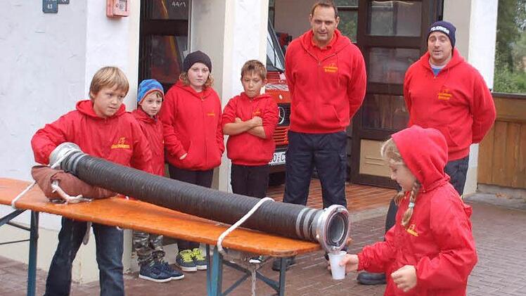 Aufregung liegt in der Luft: Die Mädchen und Jungen üben für den zweiten Kinderfeuerwehr-Leistungsmarsch in Oberfüllbach die Wasserbeförderung durch den Saugschlauch. Es schauen Michael Müller (links) und Michael Baudler zu.  Fotos: Gabi Arnold
