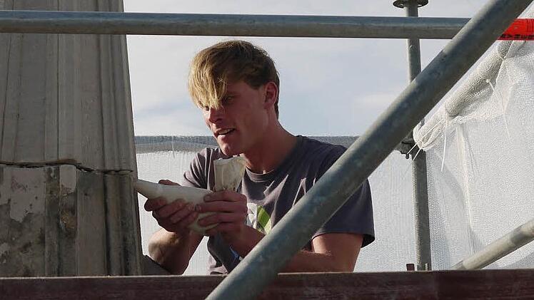 Steinmetz Steve Amthor beim Auffüllen der Risse im Sandstein. Die Tortenspritze ist für ihn dabei das beste Werkzeug. Foto: Ulrike Nauer