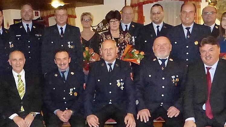 Unser Bild zeigt (sitzend, von links) Bürgermeister Franz Uome, Rainer Bauer, Werner Rödel, Johannes Taig und Landrat Klaus Peter Söllner sowie (stehend, von links) Kreisbrandinspektor Thomas Limmer, Kreisbrandmeister Yves Wächter, Daniel Schramm, Yvonne Kögler, Cornelia Rödel, Hans Kögler, Thomas Greim, Josef Kießling, zweiten Kommandanten Stefan Mähringer und Edeltraud Kießling. Foto: Klaus-Peter Wulf