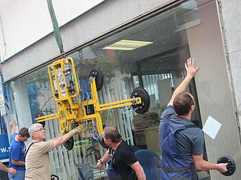 Die neue Schaufensterscheibe wird eingepasst. Das erfordert Kraft und Augenmaß. Fotos: Marco Meißner