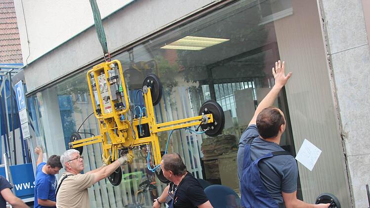 Die neue Schaufensterscheibe wird eingepasst. Das erfordert Kraft und Augenmaß. Fotos: Marco Meißner