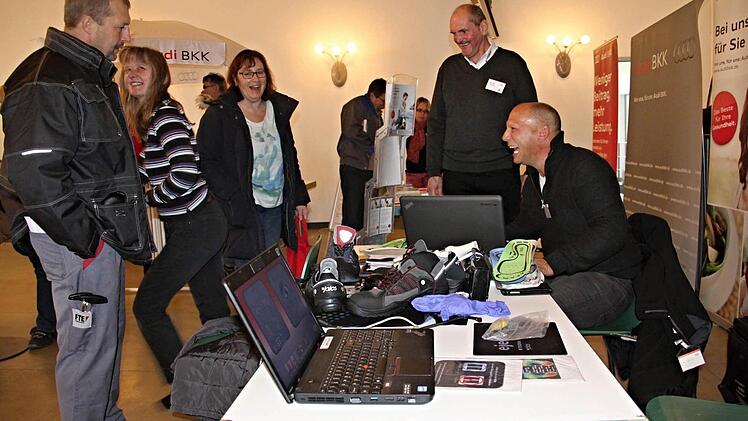 Mit computergesteuerter Technik wurde von Willi Pfeil (rechts) der ideale Arbeits- oder Freizeitschuh ermittelt. Michael Bezdeka (Zweiter von rechts), bei FTE zuständig für Gesundheitsmanagement, freut sich über den Laufversuch der Mitarbeiterin (Zweite von links). Foto: Helmut Will
