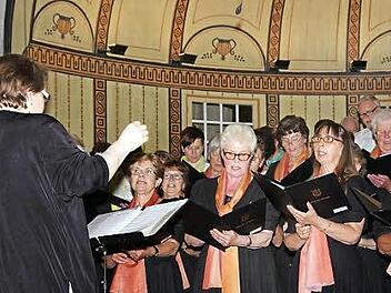 Andrea Metzler dirigiert den Frauenchor des Gesangvereins Garitz. Moderatorin des Abends war Regina Bolgen (Mitte). Foto: Klaus Werner