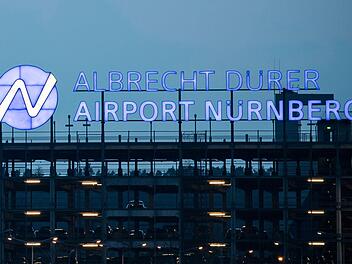 Nürnberg: Der Schriftzug "Albrecht-Dürer-Airport" leuchtet auf dem Parkhaus des Flughafens. Am 11. April fand die Jahrespressekonferenz des Flughafens Nürnberg statt. Der Airport meldet steigende Gewinne und einen neuen Passgierrekord. Foto: Daniel Karmann/dpa