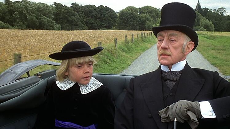 Der kleine Cedric Errol (Ricky Schroder, links) reist auf Wunsch seines Gro&szlig;vaters Earl of Dorincourt (Alec Guinness) nach England. Auf dem Schloss Dorincourt soll der Junge eine standesgem&auml;&szlig;e Erziehung genie&szlig;en.