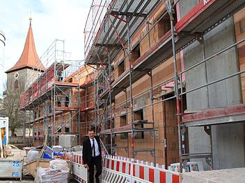 Wo früher einmal das Gasthaus Mehl und das alte Schulhaus standen, zieht ein privater Investor einen Gebäudekomplex hoch, dessen mittleren Teil die Caritas gekauft hat. Bürgermeister Ludwig Wahl freut sich über diese Entscheidung.  Foto: Andreas Dorsch