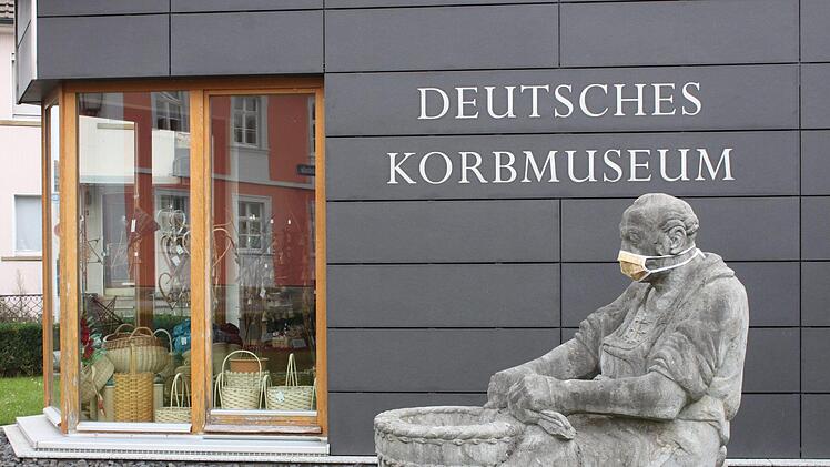 Der steinerne Korbmacher vor dem Deutschen Korbmuseum trägt eine Mund-Nasen-Maske. Das wird auch von den Besuchern erwartet.