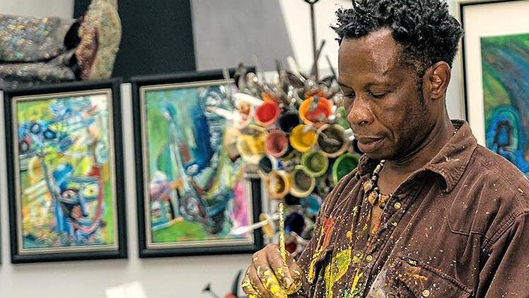 Künstler Chidi Kwubiri in seinem Atelier in Pulheim bei Köln, in dem die für ihn so typischen Bilder in Dripping-Technik entstehen.  Foto: Misereor