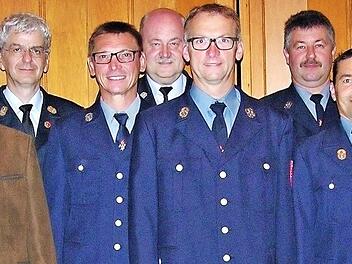 Kommandant Dirk Bauer (Zweiter von links) und Bürgermeister Michael Keilich (Zweiter von rechts) mit Ehrengästen und den im Rahmen der FW-Hauptversammlung für langjährige ehrenamtliche Dienstzeit ausgezeichneten Aktiven  Foto: Klaus Oelzner