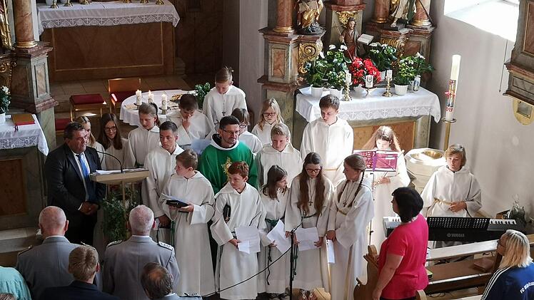 Pater Flavian bei seiner Verabschiedung in der Pfarrkirche  St. Erhard Wichsenstein inmitten seiner Ministranten. Am Rednerpult der  stellvertretende Pfarrgemeinderatsvorsitzende Joachim Roppelt.                   Foto: Thomas Weichert