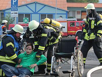 Ein Rollstuhlfahrer ist gestürzt und braucht Hilfe. Für die Feuerwehrleute kein Problem. Diese Übung meisterten sie. Fotos: Benedikt Borst