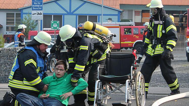 Ein Rollstuhlfahrer ist gestürzt und braucht Hilfe. Für die Feuerwehrleute kein Problem. Diese Übung meisterten sie. Fotos: Benedikt Borst