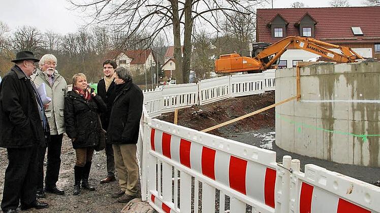 Wie geht es weiter mit dem Löschwasserbehälter? Die weiße Linie am Bauwerk zeigt den Vorschlag von Bürgermeister Dieter Adam (links), dort den Behälter abzuschneiden. Hauptkonservator Ulrich Kahle (rechts) sowie die Landratsamts-Juristen Jürgen Meins (Zweiter von links) und Philipp Hetzel (Zweiter von rechts) schlugen vor, den Behälter bis zur grünen Linie zu kappen, die das alte Geländeniveau darstellt. Mit im Bild Martina Hagenbucher von der Unteren Denkmalschutzbehörde.  Foto: Jürgen Gärtner