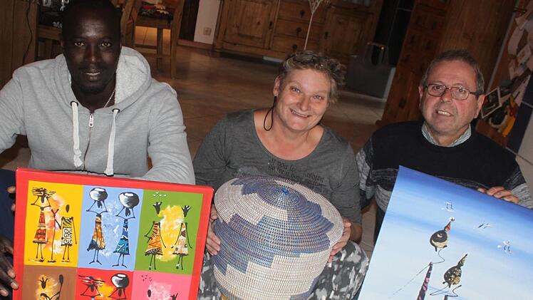 Karin und Theo Wittmann mit ihrem Schwiegersohn Bruno Diouf und einigen Mitbringseln ihrer Afrika-Reise Foto: Matthias Einwag
