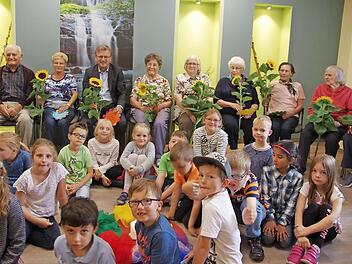 Die Schüler der Klasse 1 a der Grundschule Stockheim sind Freunde und Partner der Tagespflege Baierlein und bringen mit ihrem Besuch nicht nur Geschichten, Gedichte und Gesänge, sondern haben auch Sonnenblumen zur Freude für die Senioren dabei. Foto: K.- H. Hofmann