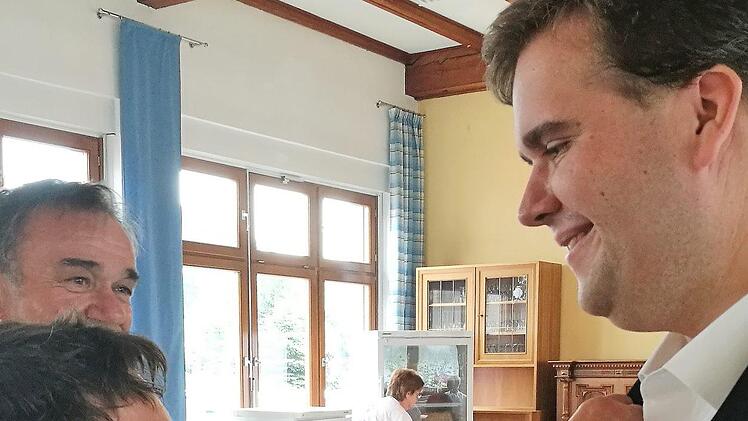 Maria Gerstner vom KAB-Büro Kronach steckte Präses Dekan Pötzl  das KAB-Kreuz an.