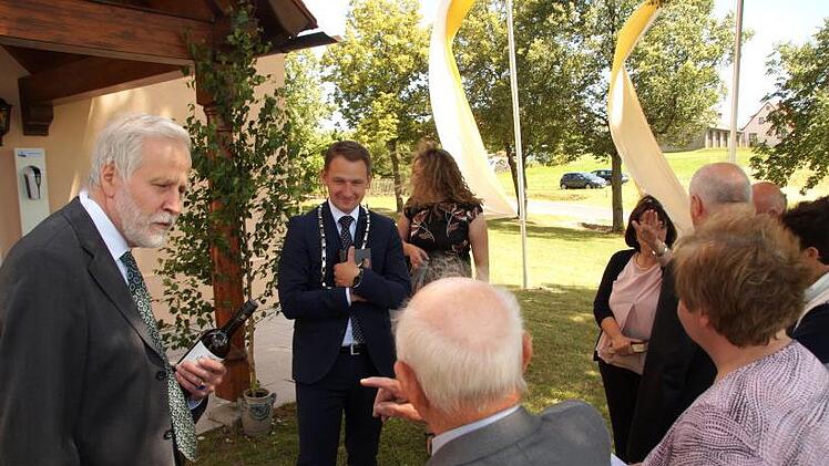 Baptist Bezold (mit dem Rücken) erzählt in lustiger Runde über das Baugeschehen.