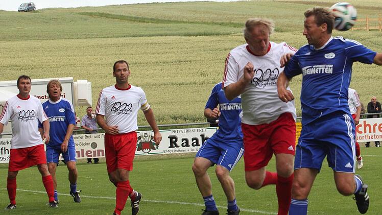 Klaus Werner (Zweiter von rechts) bleibt Sieger im Kopfballduell mit Guido Buchwald (rechts).