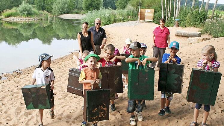 Die Kinder sind stolz auf ihre kunstvollen Fledermauskästen. Silvia Tinter, Erhard Dotterweich und Sabine Brehm (von links) haben sie bei den Montagearbeiten unterstützt.