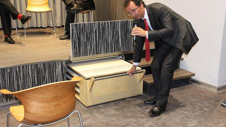 Andreas Engel zeigt, wo die Klapptische ihren Platz haben.