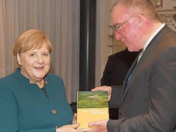 Haik Thomas Porada &uuml;berreicht Bundeskanzlerin Angela Merkel den Band "Fr&auml;nkische Schweiz".  Foto: pr