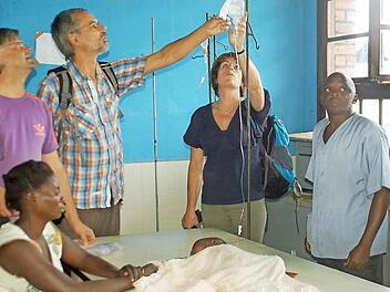 Eine junge Mutter hat ihr krankes Baby in die Kinderstation des Krankenhauses in Kangu gebracht. "In Deutschland könnten wir helfen", sagt Sigrid Gerding (Zweite von rechts). Links: Martin Lücke und Heiner Stepper von der Coburger Delegation. Fotos: Gabi Arnold
