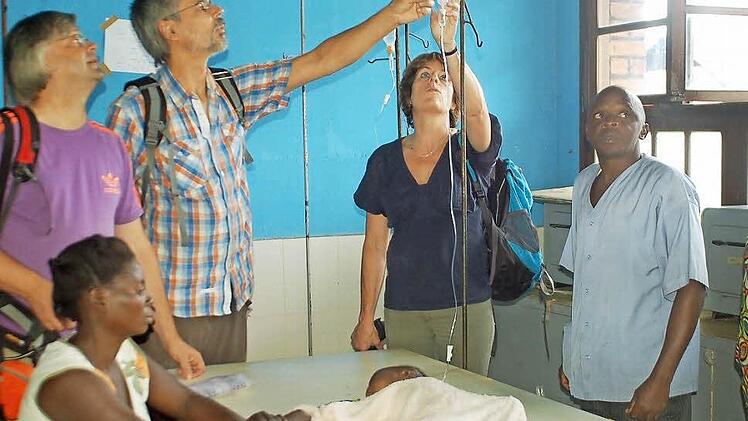 Eine junge Mutter hat ihr krankes Baby in die Kinderstation des Krankenhauses in Kangu gebracht. "In Deutschland könnten wir helfen", sagt Sigrid Gerding (Zweite von rechts). Links: Martin Lücke und Heiner Stepper von der Coburger Delegation. Fotos: Gabi Arnold