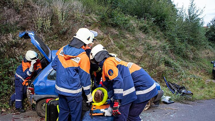 Aus einem Unfallfahrzeug wird eine verletzte Person geborgen.