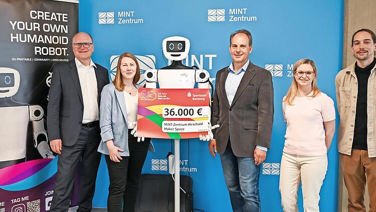 Stephan Kirchner (links) und Frank Seuling (Dritter von rechts) mit seinem Mint-Team und dem humanoiden Roboter &bdquo;pib&ldquo; bei der symbolischen Scheck&uuml;bergabe.